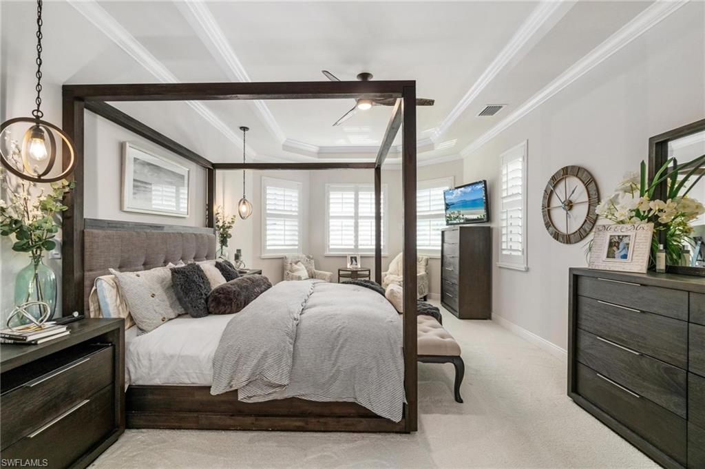 8936 Mustique Lane Naples, FL 34114 - Photo 13 of 29 a bedroom with a bed a mirror on dresser and a window