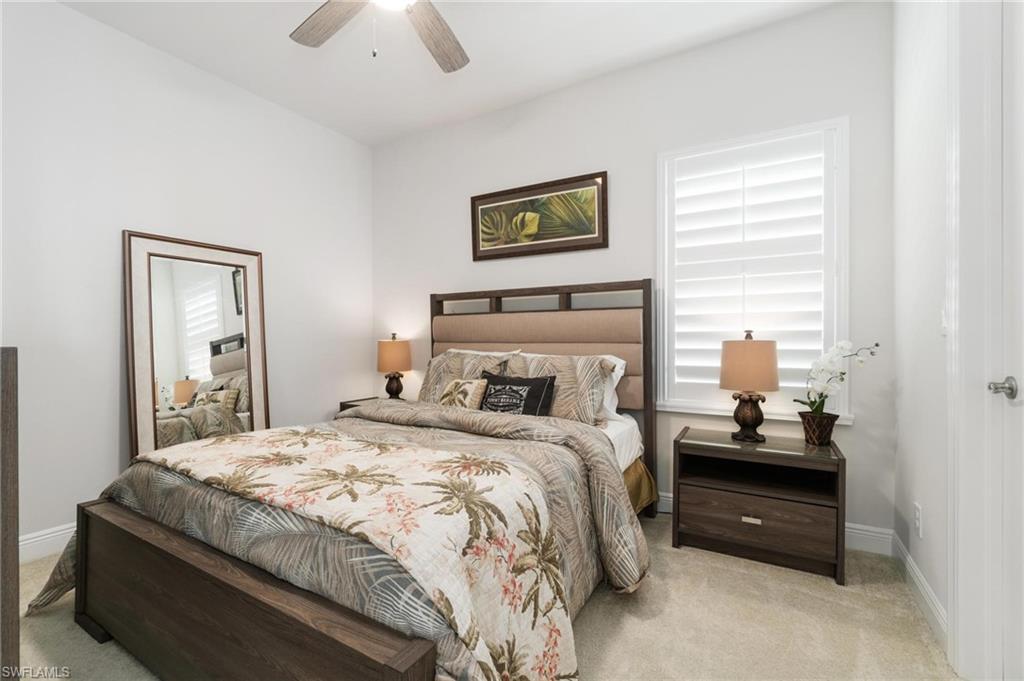 8936 Mustique Lane Naples, FL 34114 - Photo 19 of 29 a bedroom with a bed and a lamp