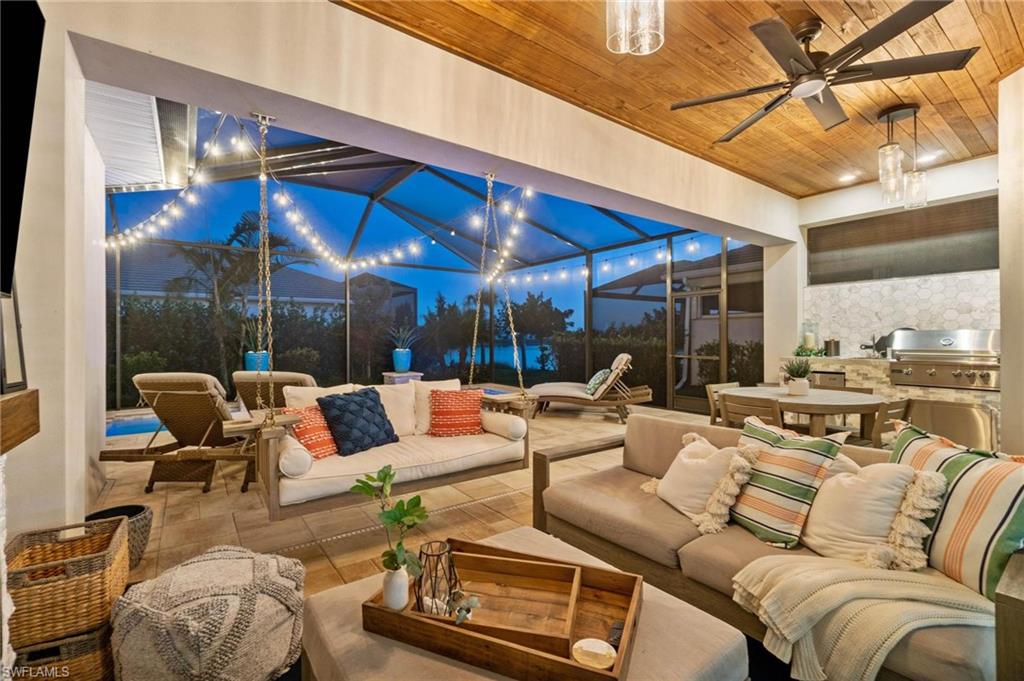 8936 Mustique Lane Naples, FL 34114 - Photo 24 of 29 a living room with furniture a lamp and a large window