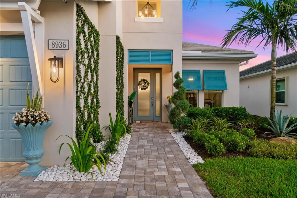 8936 Mustique Lane Naples, FL 34114 - Photo 3 of 29 a front view of a house with a yard