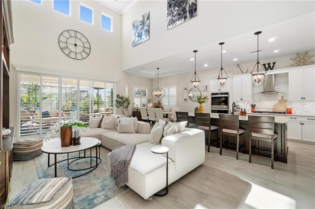 8936 Mustique Lane Naples, FL 34114 - Photo 5 of 29 a living room with furniture a clock and a large window