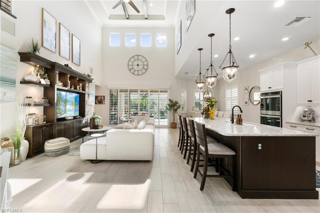 8936 Mustique Lane Naples, FL 34114 - Photo 6 of 29 a living room with furniture a large window and a clock