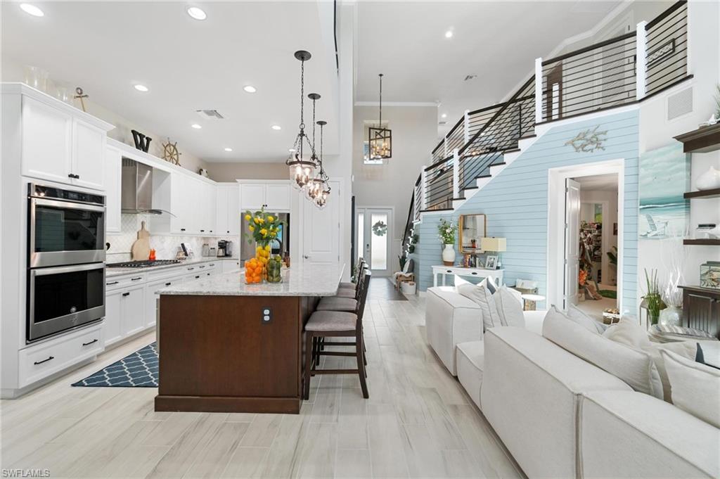 8936 Mustique Lane Naples, FL 34114 - Photo 10 of 29 a living room with furniture kitchen view and a wooden floor