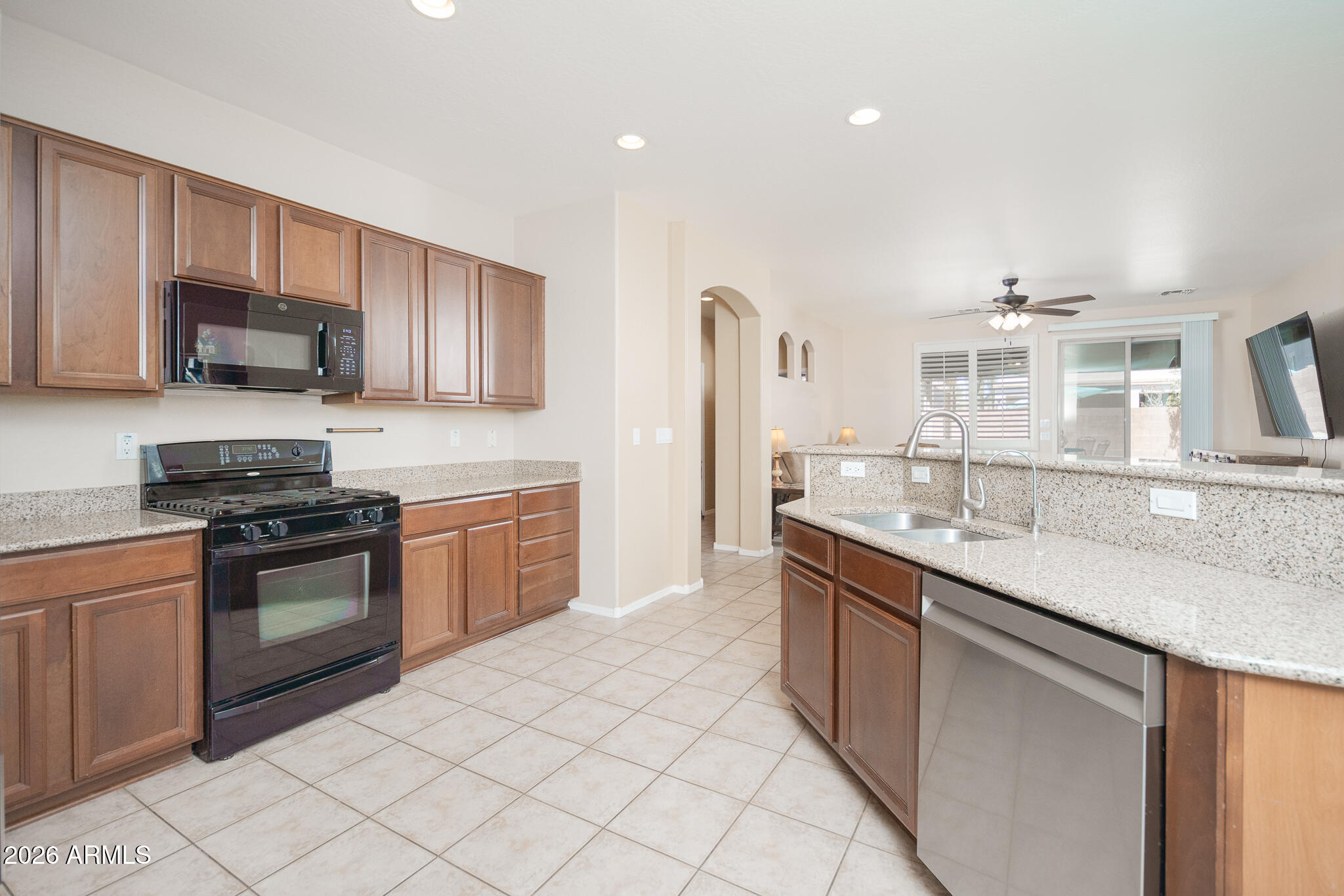 17284 West Madison Street Goodyear, AZ 85338 - Photo 10 of 34 a kitchen with stainless steel appliances granite countertop a sink and stove top oven