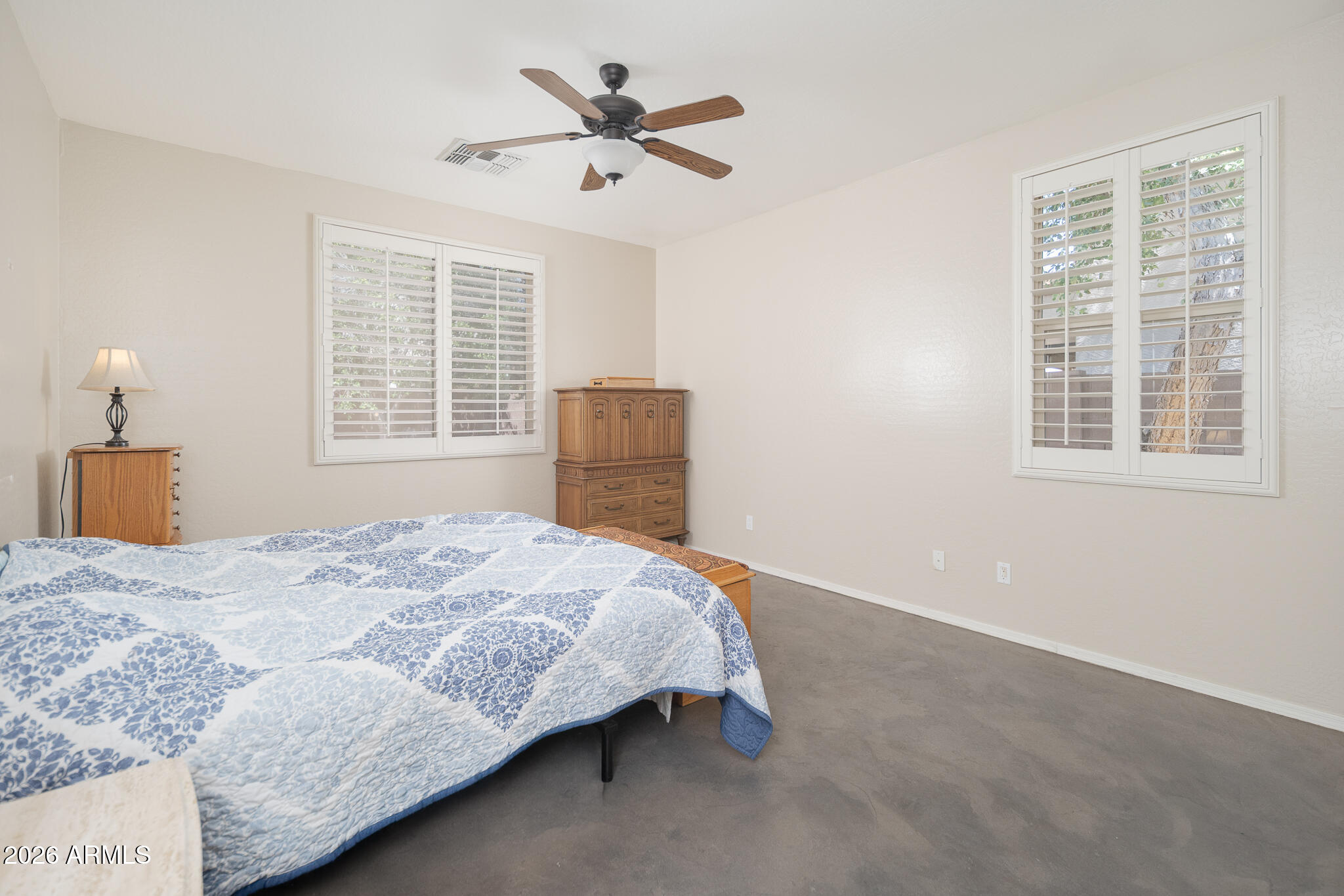 17284 West Madison Street Goodyear, AZ 85338 - Photo 15 of 34 a bedroom with a bed a dresser and a window