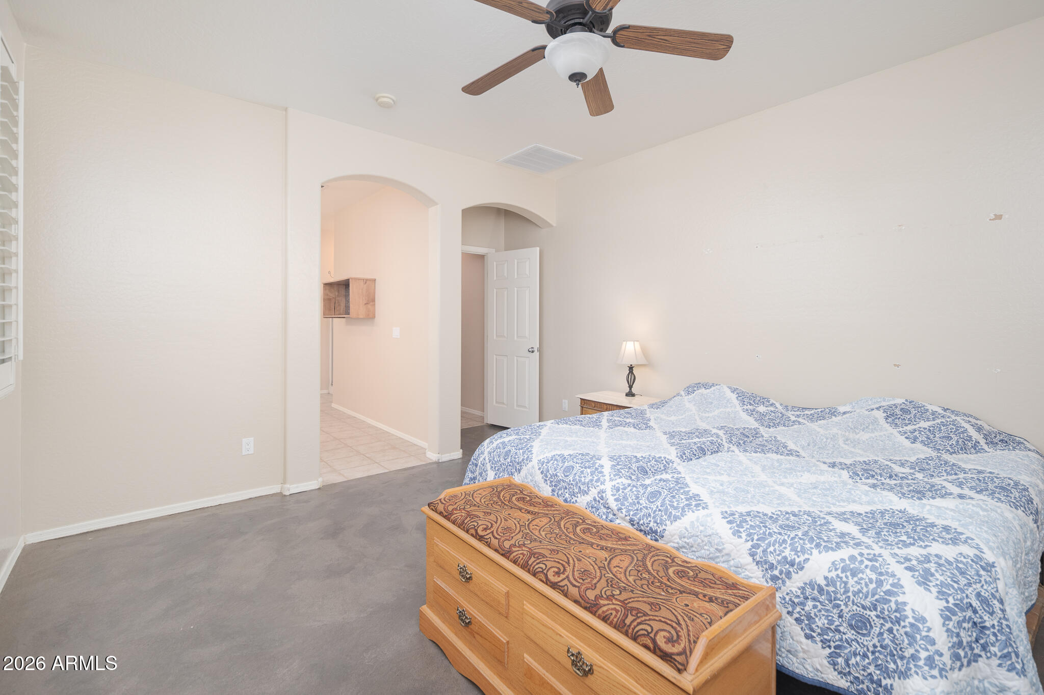 17284 West Madison Street Goodyear, AZ 85338 - Photo 16 of 34 a bedroom with a bed and ceiling fan
