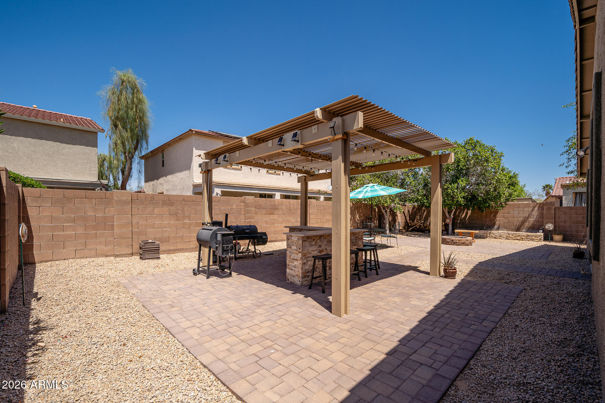 17284 West Madison Street Goodyear, AZ 85338 - Photo 29 of 34 a view of a patio with a table and chairs under an umbrella