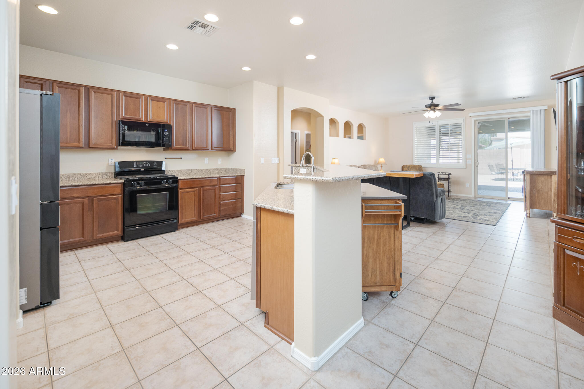 17284 West Madison Street Goodyear, AZ 85338 - Photo 9 of 34 a kitchen with stainless steel appliances granite countertop a stove top oven a sink a counter top space and cabinets