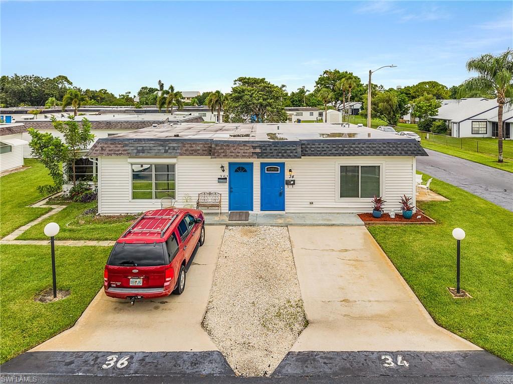 34 Hamlin Court Lehigh Acres, FL 33936 - Photo 23 of 29 a car parked in front of a house with a yard