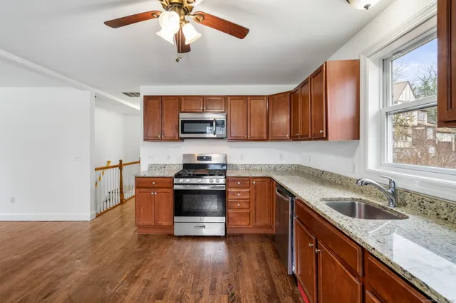 a kitchen with granite countertop a sink appliances and cabinets