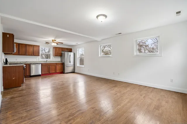 a view of a kitchen with a sink stove cabinets and empty room