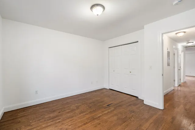 a view of a room with wooden floor and white walls