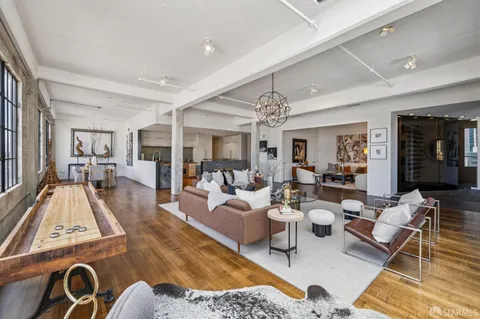 a living room with furniture and a chandelier