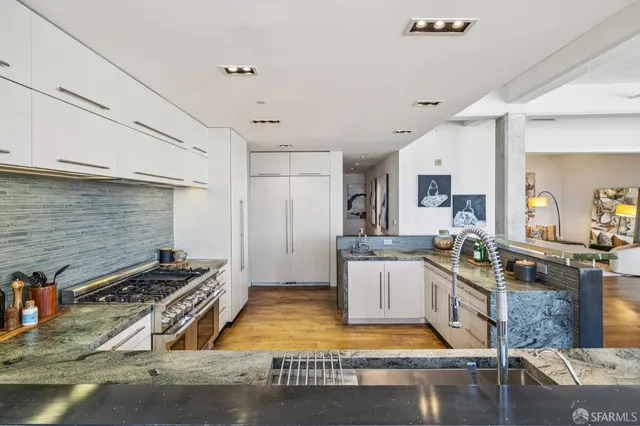 a large kitchen with stainless steel appliances granite countertop a stove a sink and a granite counter tops