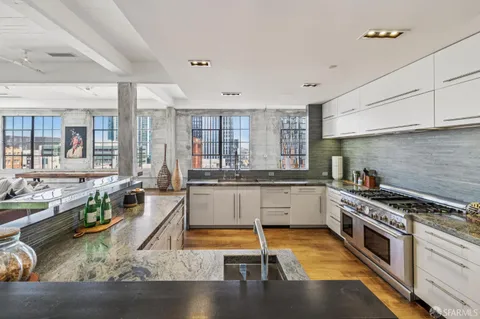 a kitchen with granite countertop a stove and white cabinets