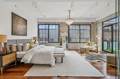 a large bedroom with bed and large windows