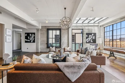 a living room with furniture large window and wooden floor