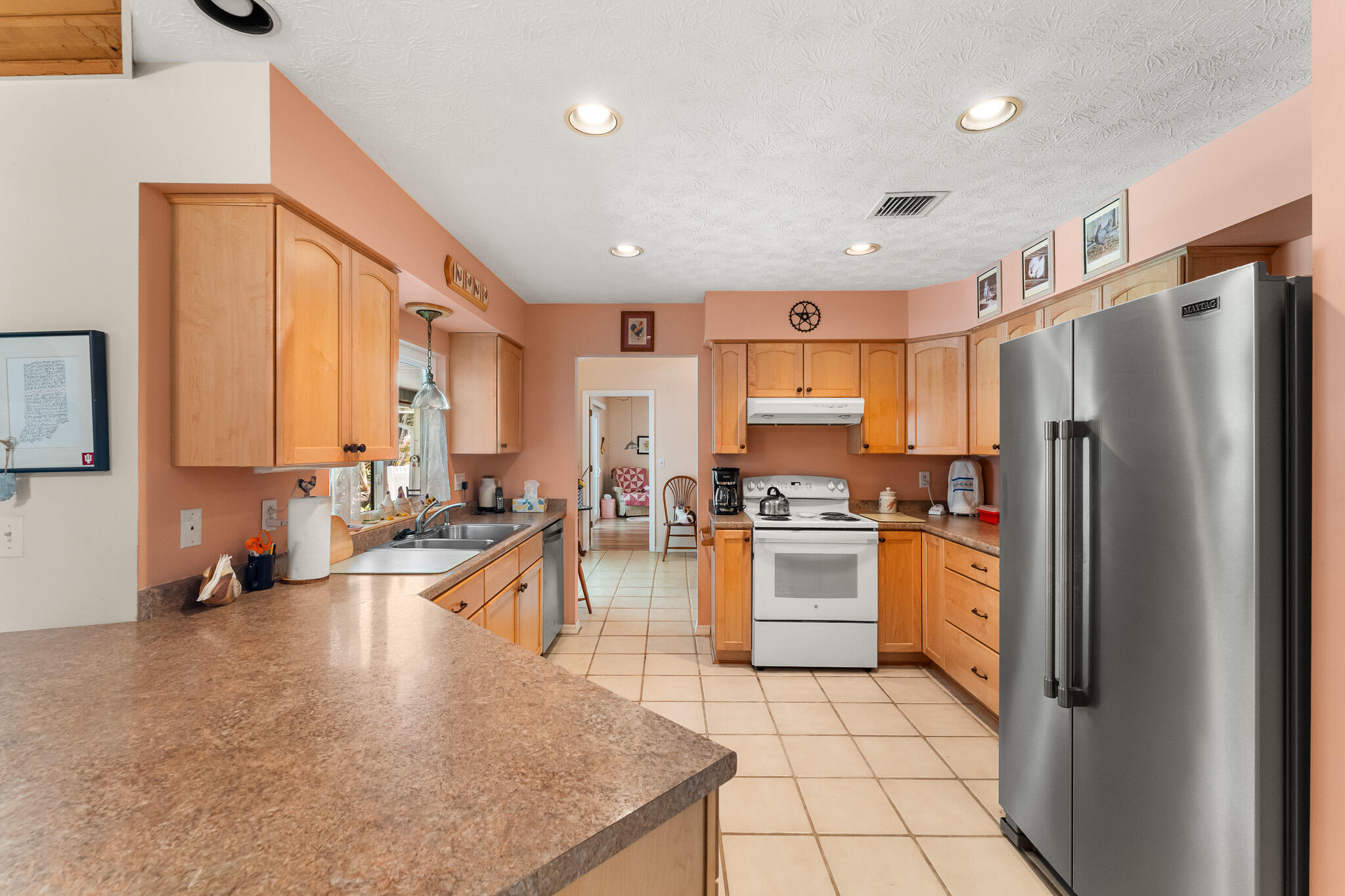 1653 Southwest 85th Terrace Stuart, FL 34997 - Photo 26 of 54 a kitchen with stainless steel appliances granite countertop a refrigerator a sink a stove and white cabinets with wooden floor