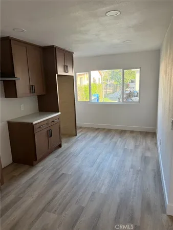 a view of a kitchen with wooden floor and electronic appliances