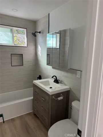 a bathroom with a sink toilet vanity and bathtub