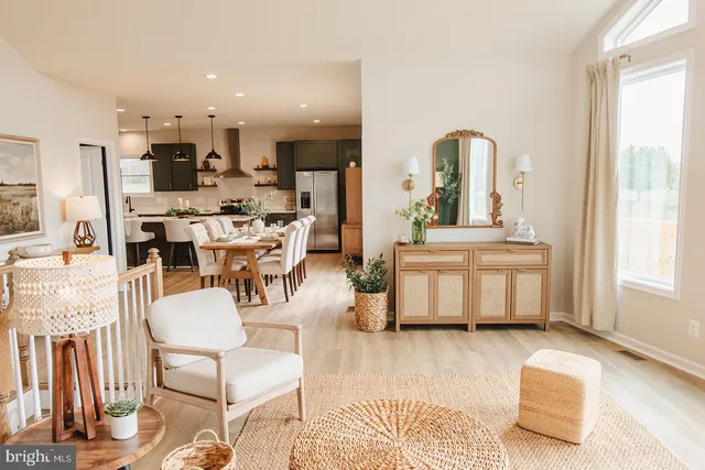 a kitchen with stainless steel appliances a sink a stove a refrigerator a dining table and chairs