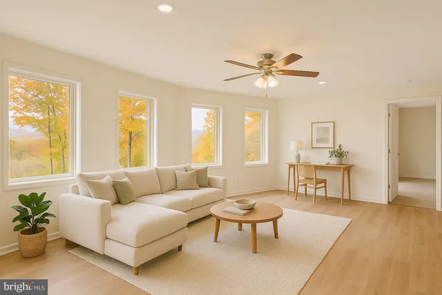 a view of an empty room with window and chandelier fan