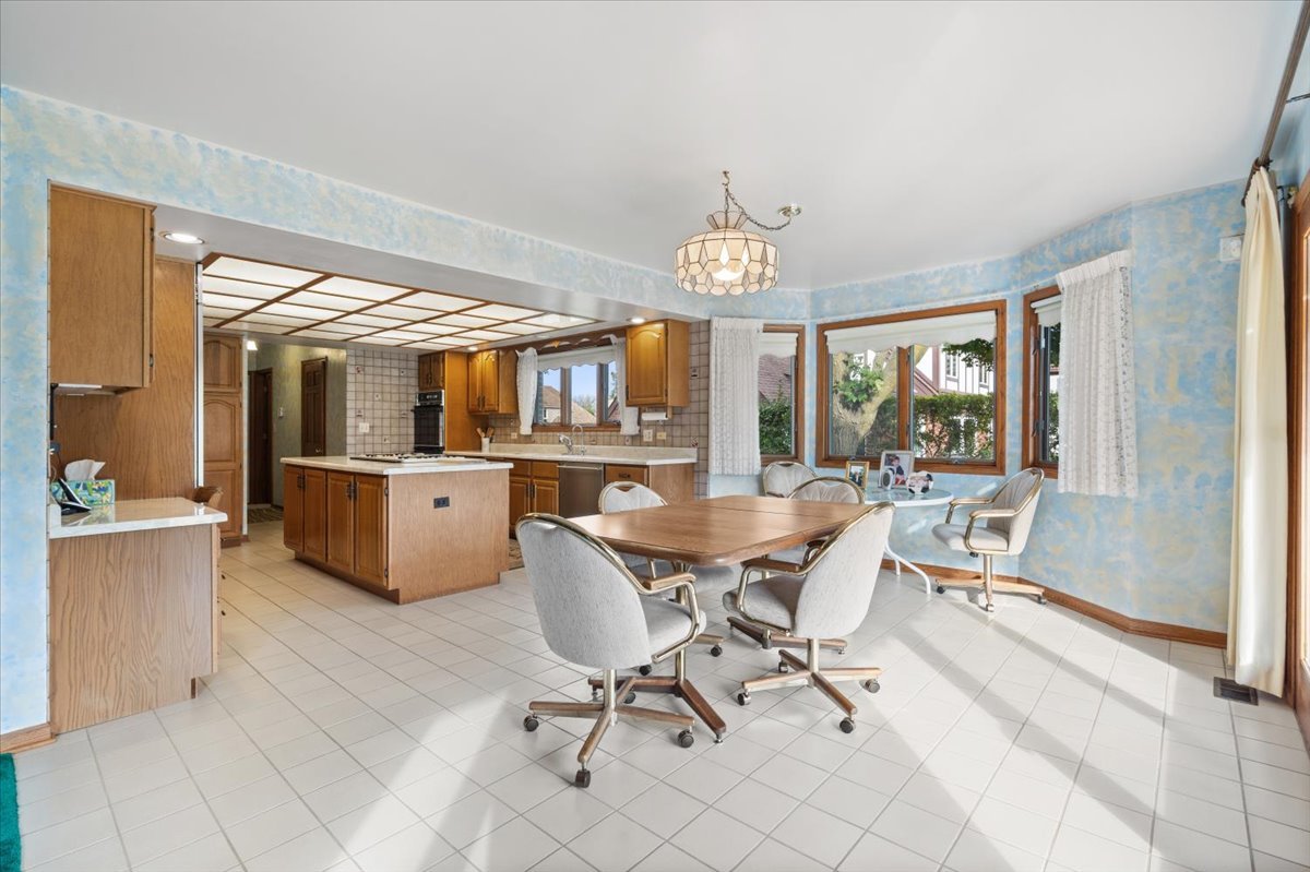 703 Newcastle Lane Prospect Heights, IL 60070 - Photo 11 of 45 a view of a dining room with furniture a chandelier and wooden floor