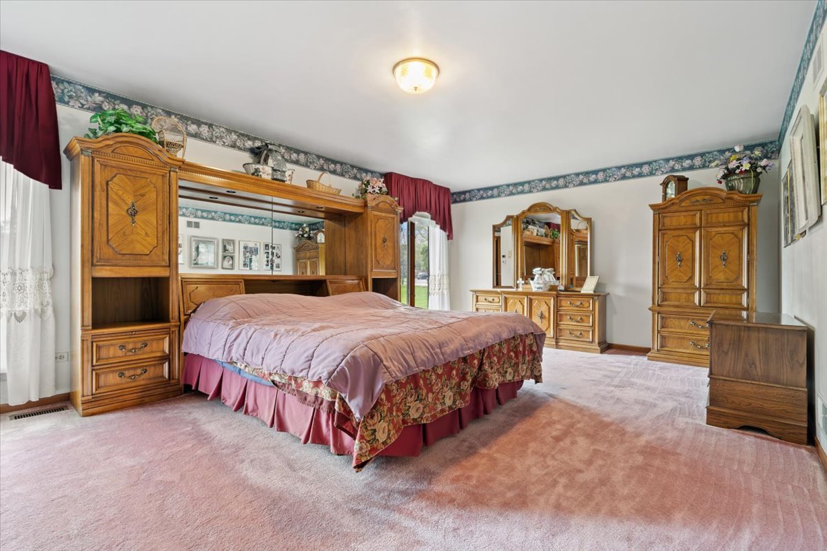 703 Newcastle Lane Prospect Heights, IL 60070 - Photo 21 of 45 a spacious bedroom with a bed and a dresser