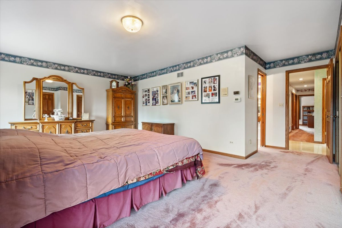 703 Newcastle Lane Prospect Heights, IL 60070 - Photo 22 of 45 a bedroom with a bed and a mirror