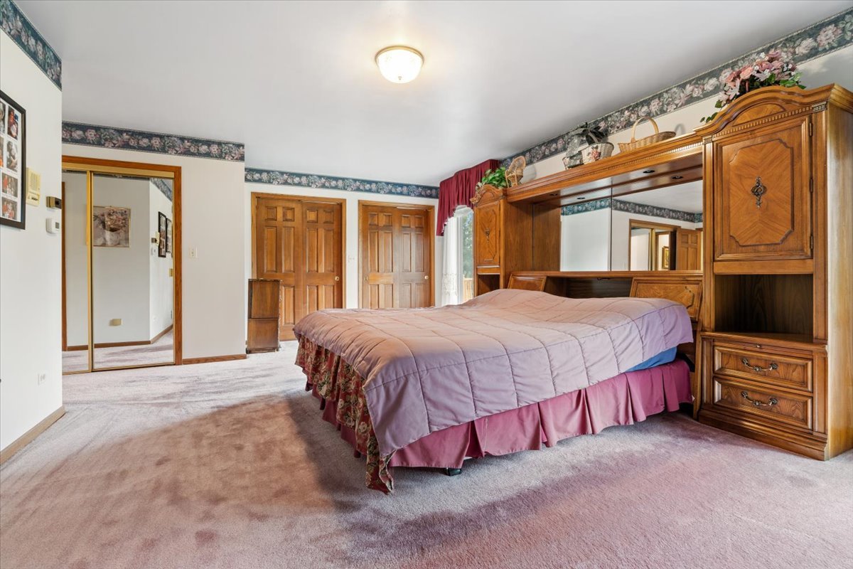 703 Newcastle Lane Prospect Heights, IL 60070 - Photo 24 of 45 a spacious bedroom with a bed a dresser and window