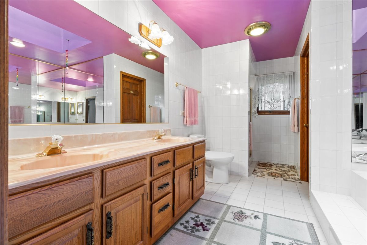 703 Newcastle Lane Prospect Heights, IL 60070 - Photo 25 of 45 a spacious bathroom with a double vanity sink toilet and a mirror