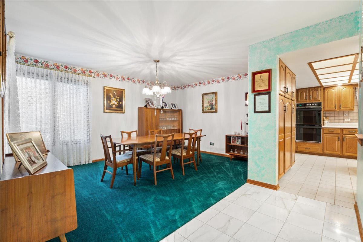703 Newcastle Lane Prospect Heights, IL 60070 - Photo 5 of 45 a view of a dining room with furniture chandelier and a kitchen