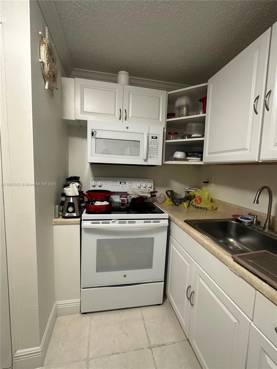 199 Southwest 12th Avenue, Unit 519B Miami, FL 33130 - Photo 10 of 25 a white stove top oven sitting inside of a kitchen