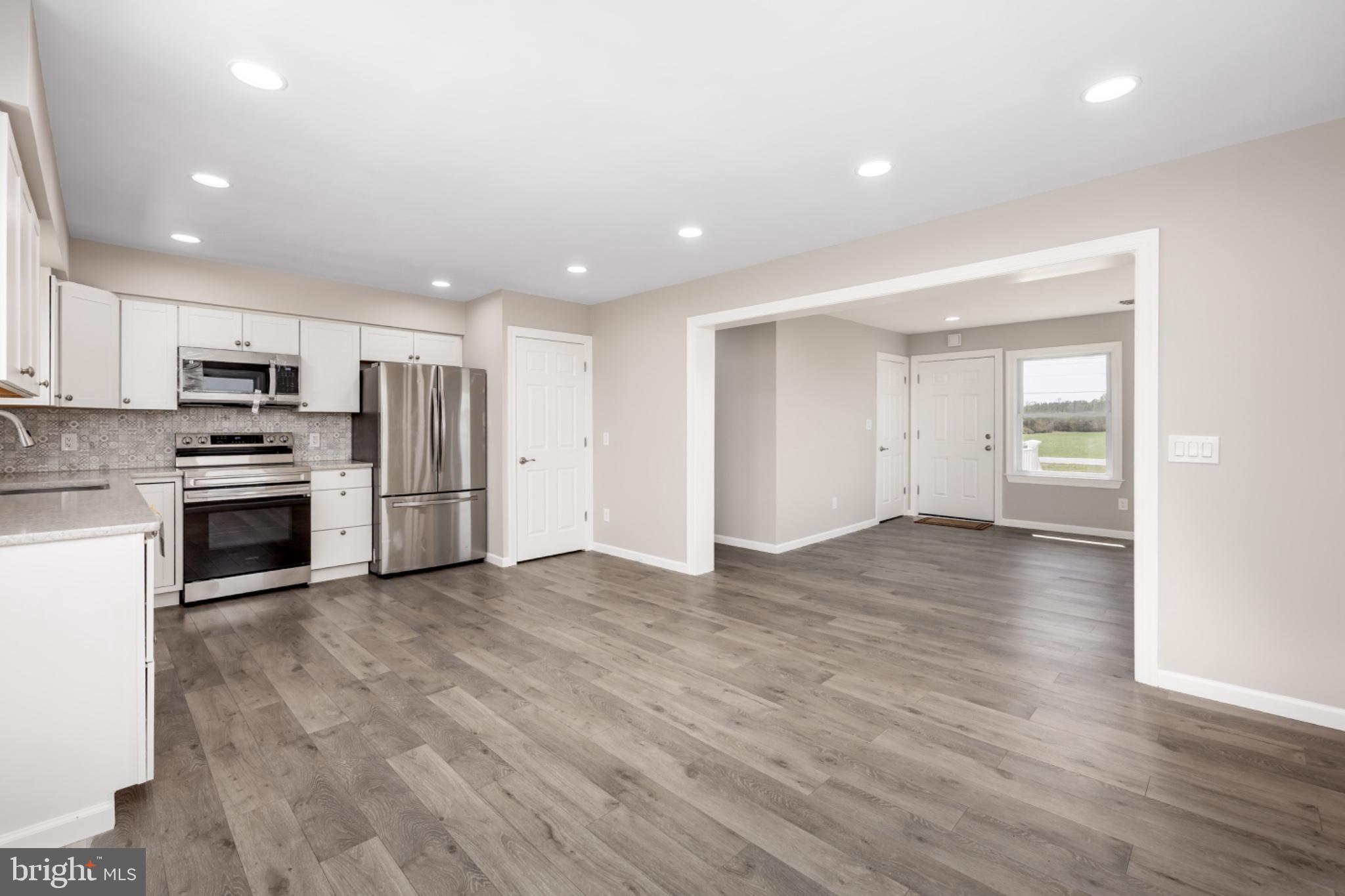 7121 Cedartown Road Snow Hill, MD 21863 - Photo 14 of 52 an empty room with stainless steel appliances wooden floor and large window