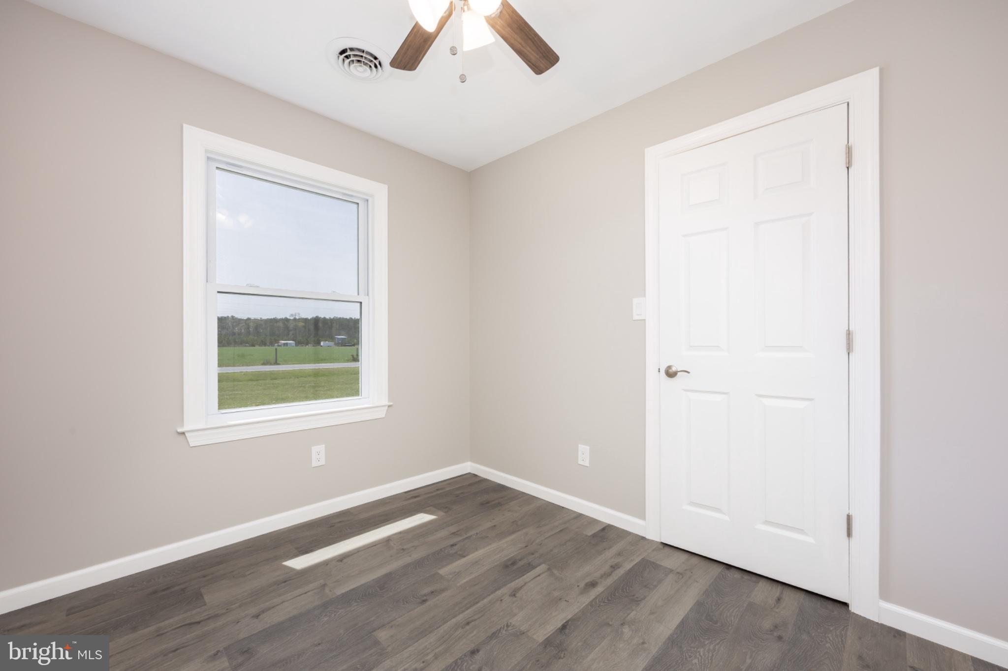 7121 Cedartown Road Snow Hill, MD 21863 - Photo 23 of 52 an empty room with wooden floor and windows