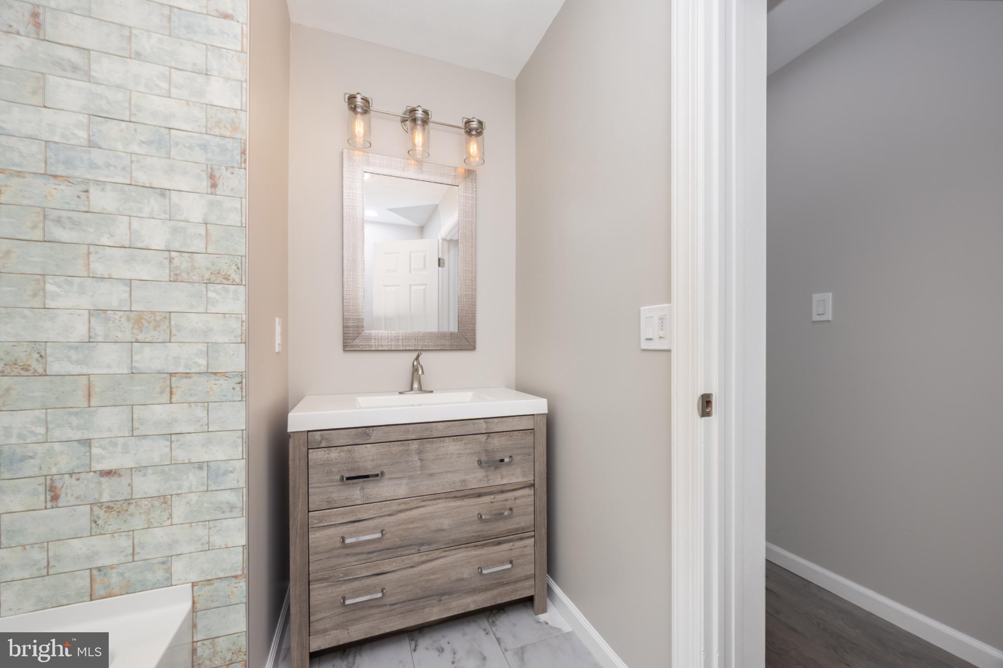 7121 Cedartown Road Snow Hill, MD 21863 - Photo 29 of 52 a bathroom with a sink a mirror and a shower