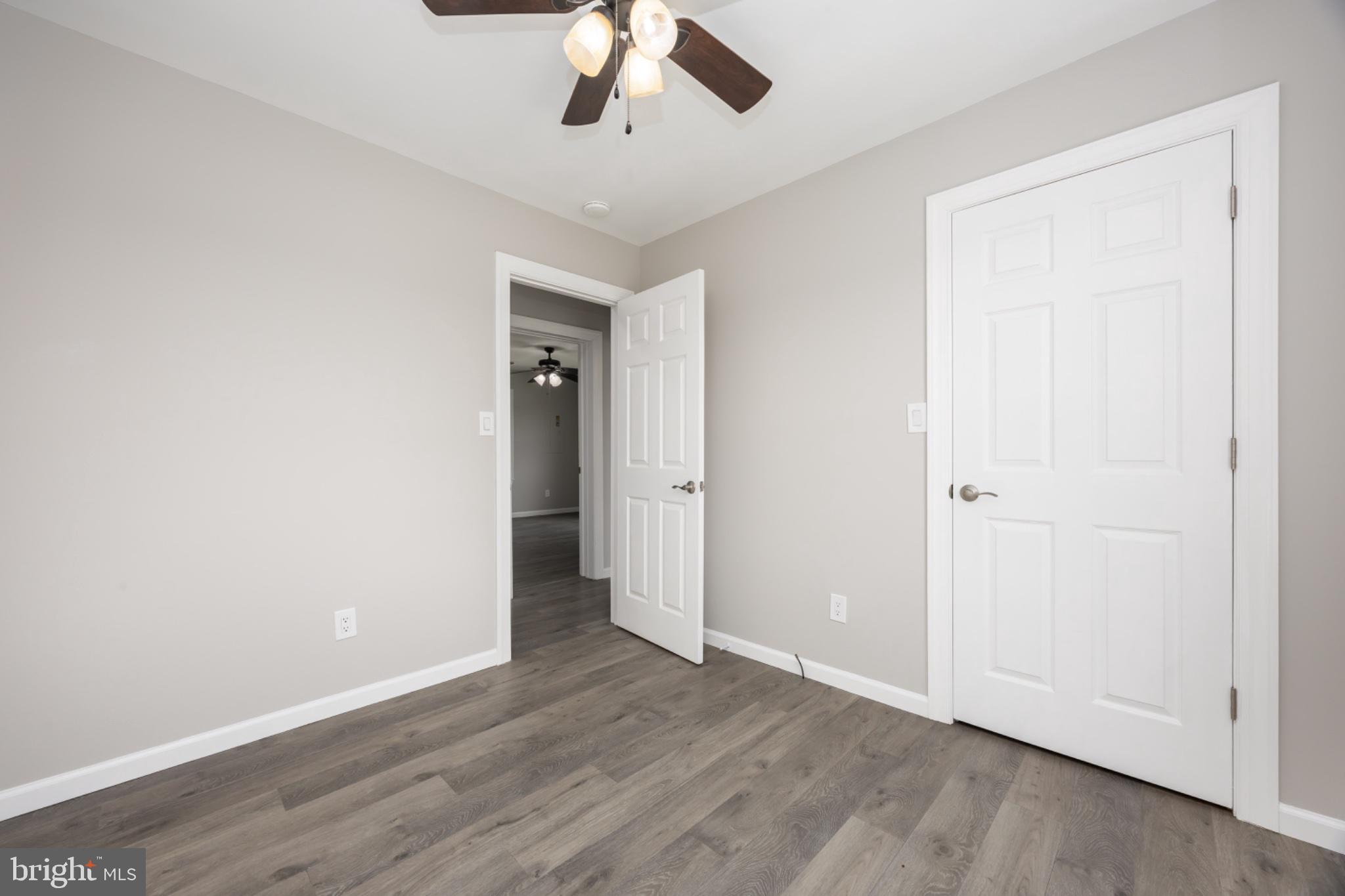 7121 Cedartown Road Snow Hill, MD 21863 - Photo 32 of 52 an empty room with wooden floor chandelier fan and closet area