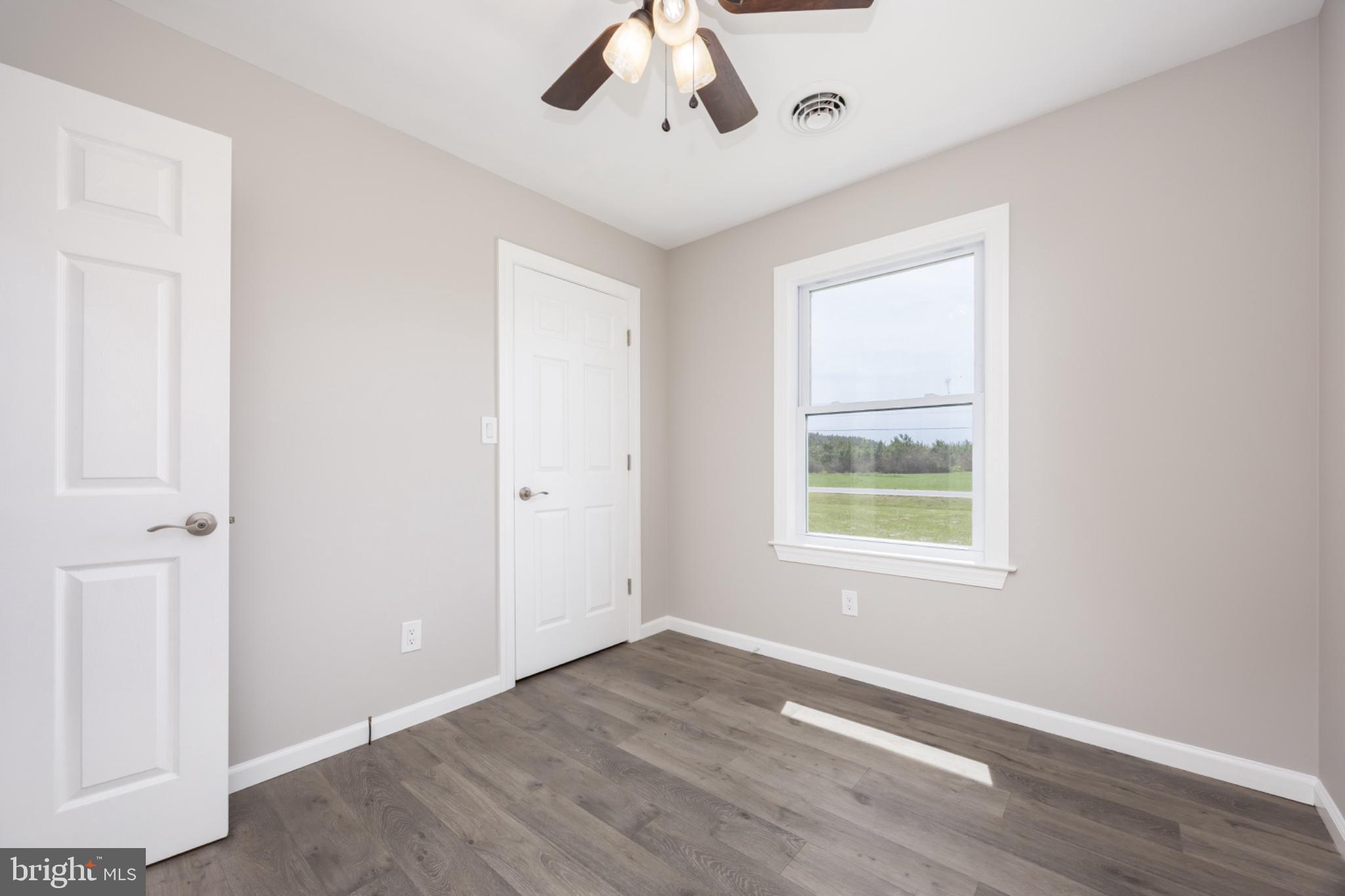 7121 Cedartown Road Snow Hill, MD 21863 - Photo 33 of 52 an empty room with wooden floor chandelier and windows
