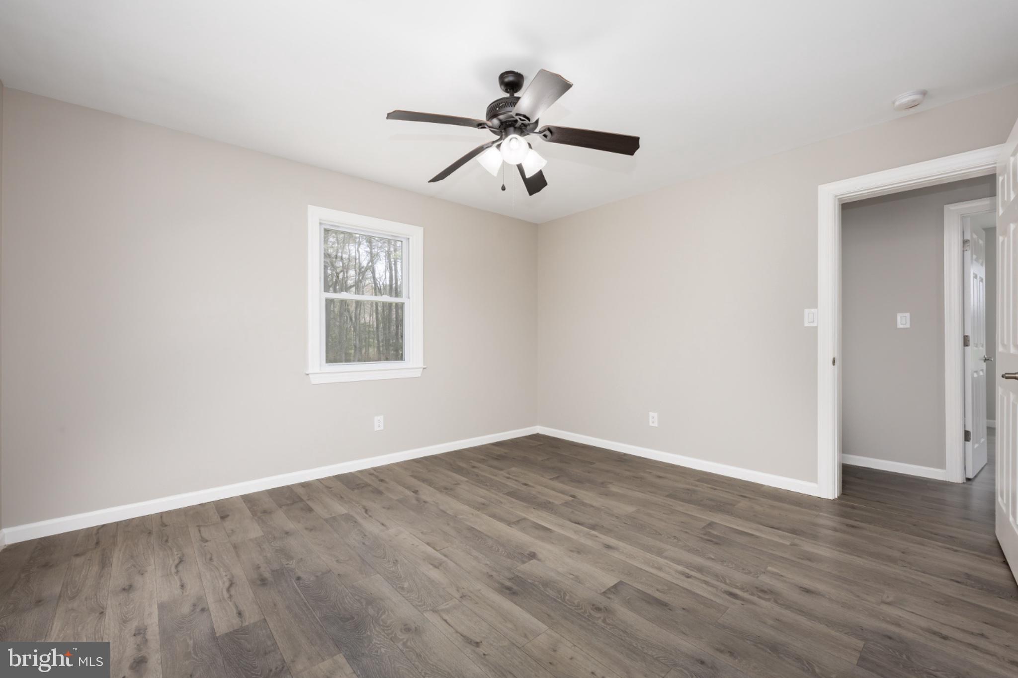 7121 Cedartown Road Snow Hill, MD 21863 - Photo 37 of 52 an empty room with wooden floor ceiling fan and windows