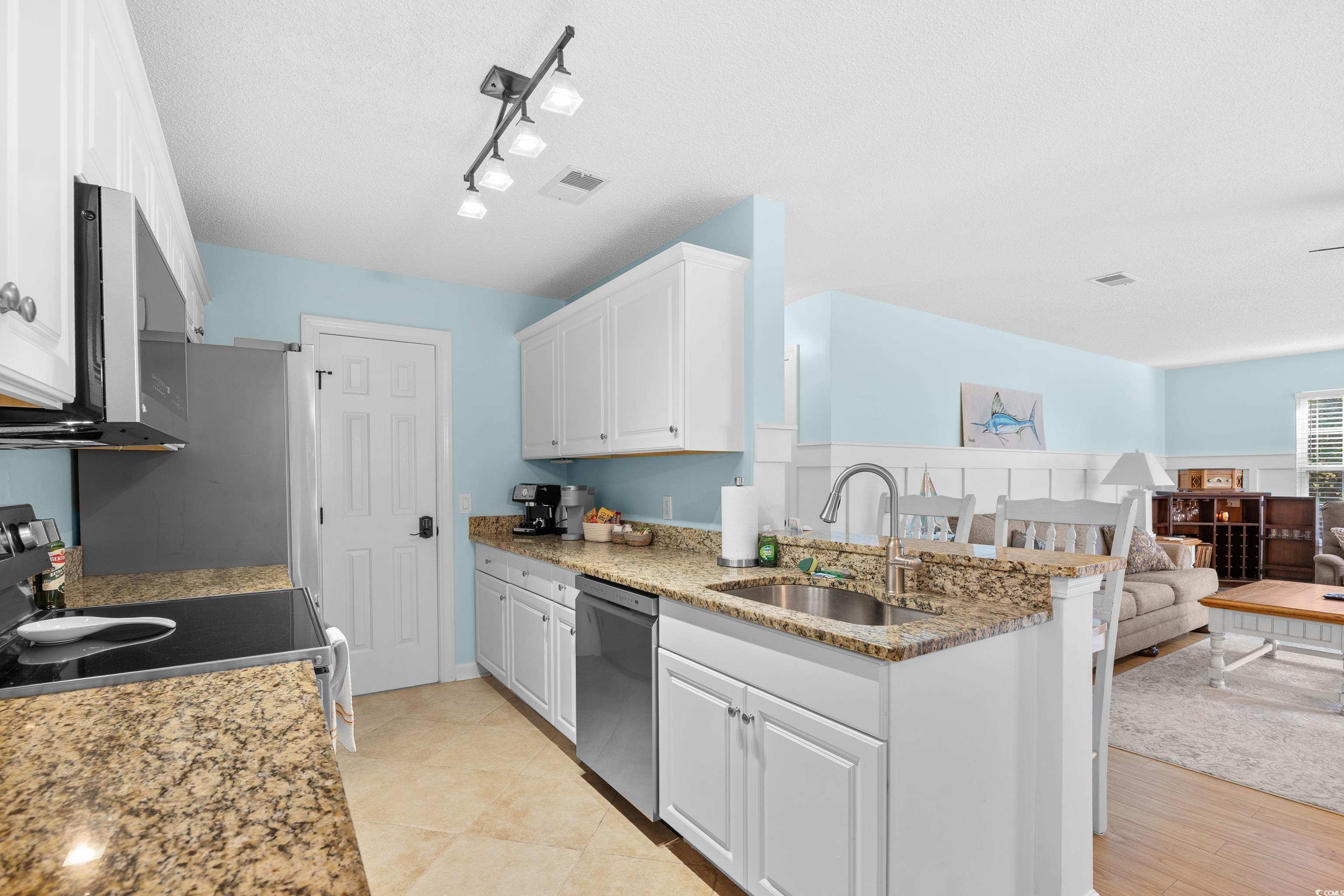 4277 Santolina Way, Unit D Murrells Inlet, SC 29576 - Photo 40 of 40 Kitchen featuring open floor plan, white cabinetry, light stone counters, stainless steel appliances, and a peninsula