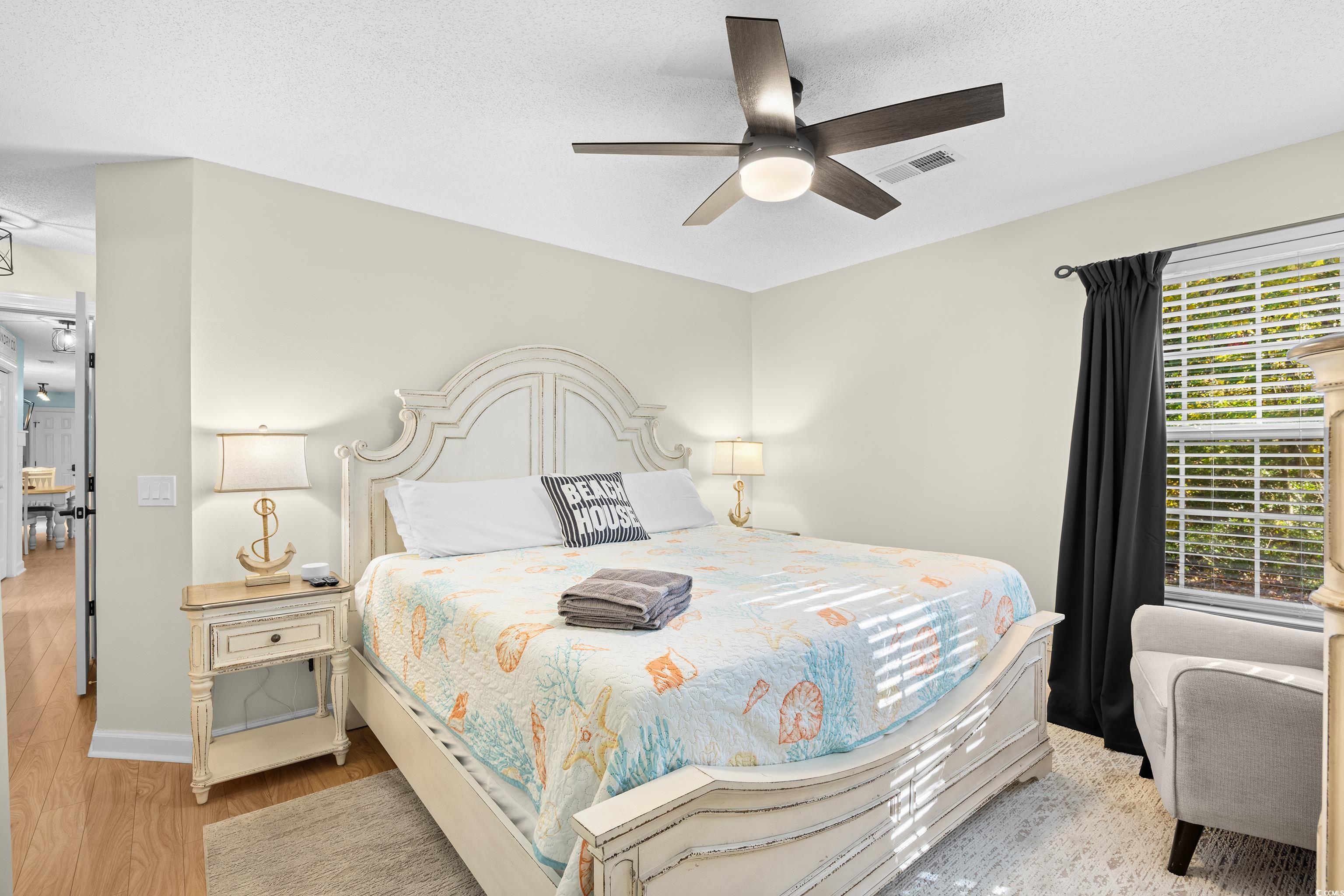 4277 Santolina Way, Unit D Murrells Inlet, SC 29576 - Photo 21 of 40 Bedroom featuring a ceiling fan, light wood finished floors, and a textured ceiling