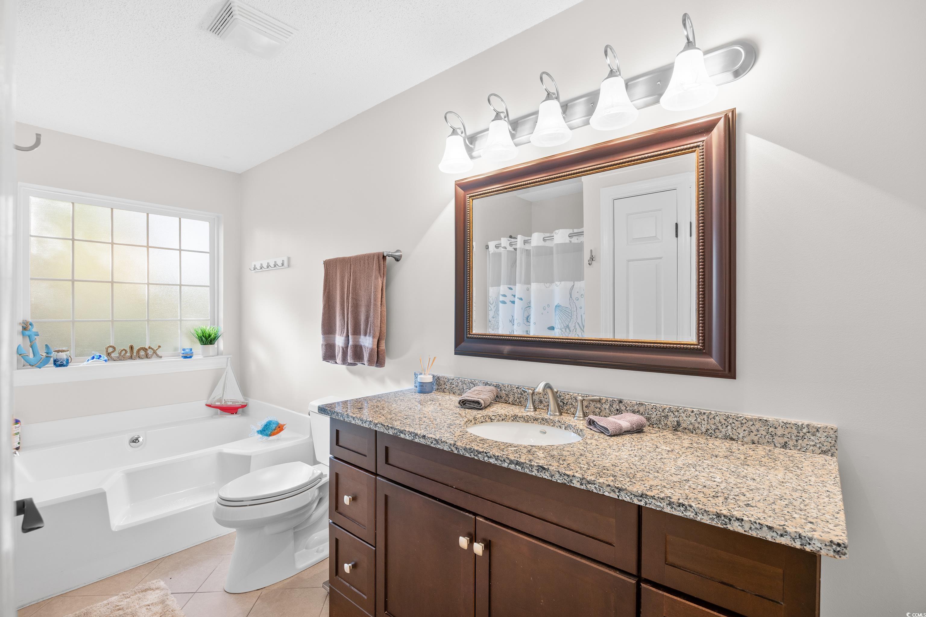 4277 Santolina Way, Unit D Murrells Inlet, SC 29576 - Photo 24 of 40 Bathroom featuring vanity, a shower with shower curtain, a garden tub, and light tile patterned floors