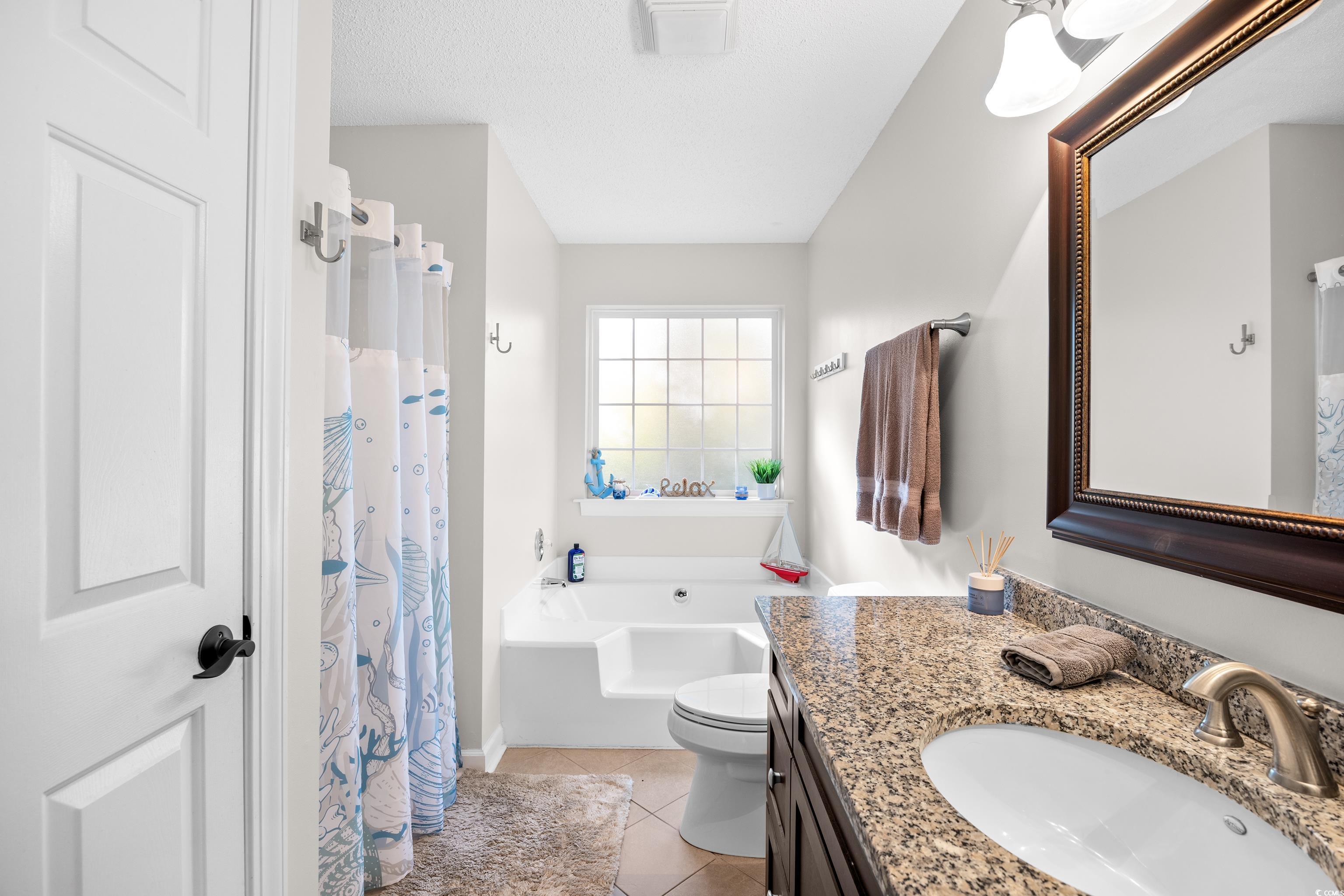 4277 Santolina Way, Unit D Murrells Inlet, SC 29576 - Photo 25 of 40 Bathroom featuring a shower with shower curtain, vanity, light tile patterned flooring, and a garden tub