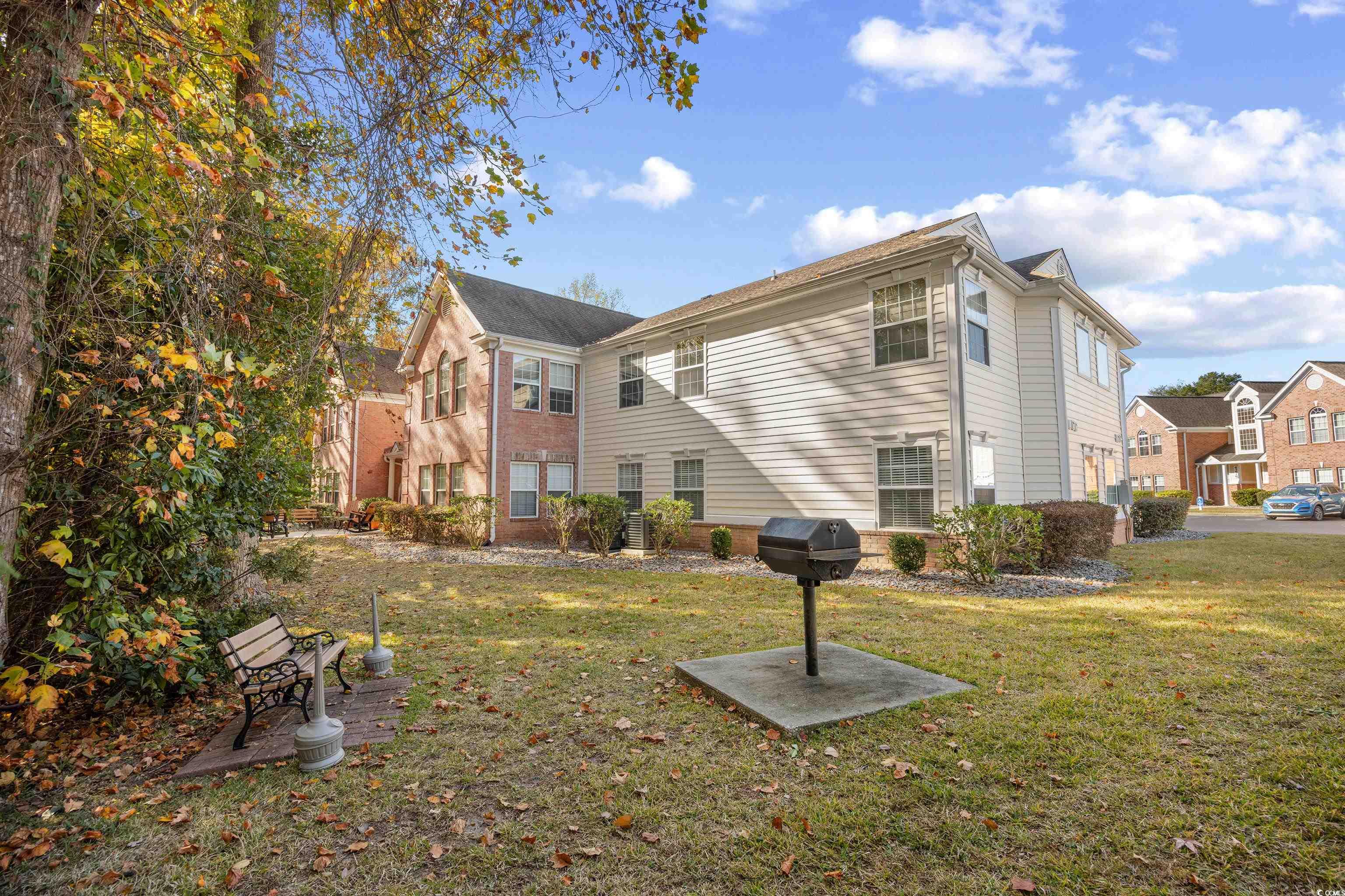 4277 Santolina Way, Unit D Murrells Inlet, SC 29576 - Photo 32 of 40 Rear view of house with brick siding and a lawn