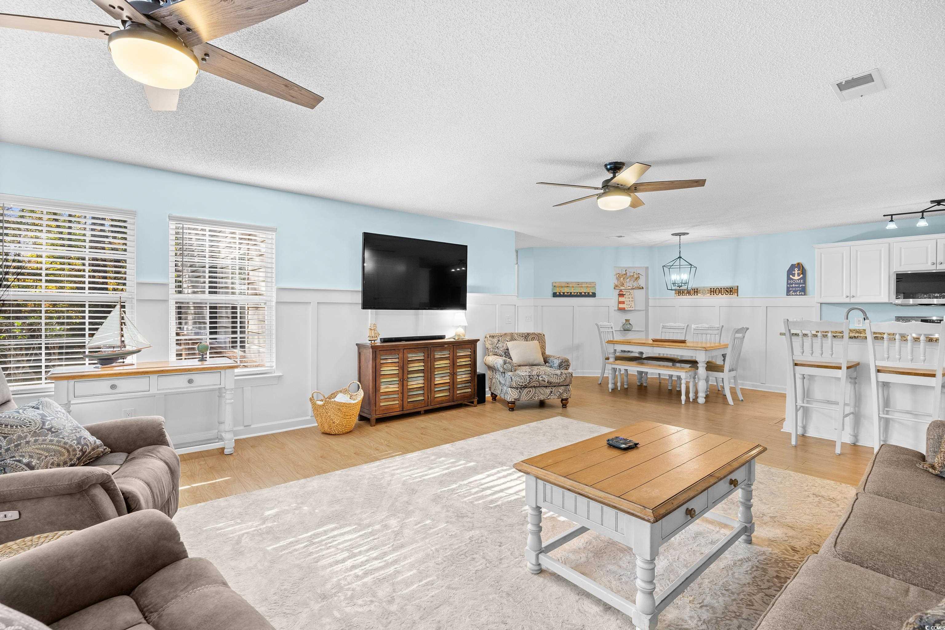 4277 Santolina Way, Unit D Murrells Inlet, SC 29576 - Photo 5 of 40 Living room with ceiling fan, light wood finished floors, a textured ceiling, wainscoting, and a decorative wall