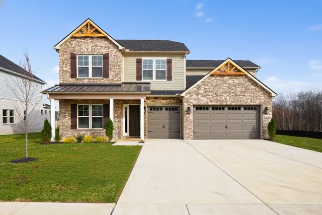 a front view of a house with a yard and trees