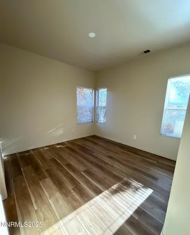 a view of a room with wooden floor and window