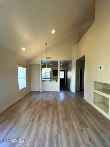 a view of empty room with wooden floor and window