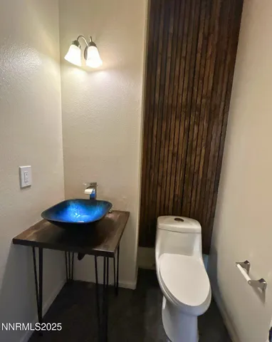 a bathroom with a toilet a sink and mirror