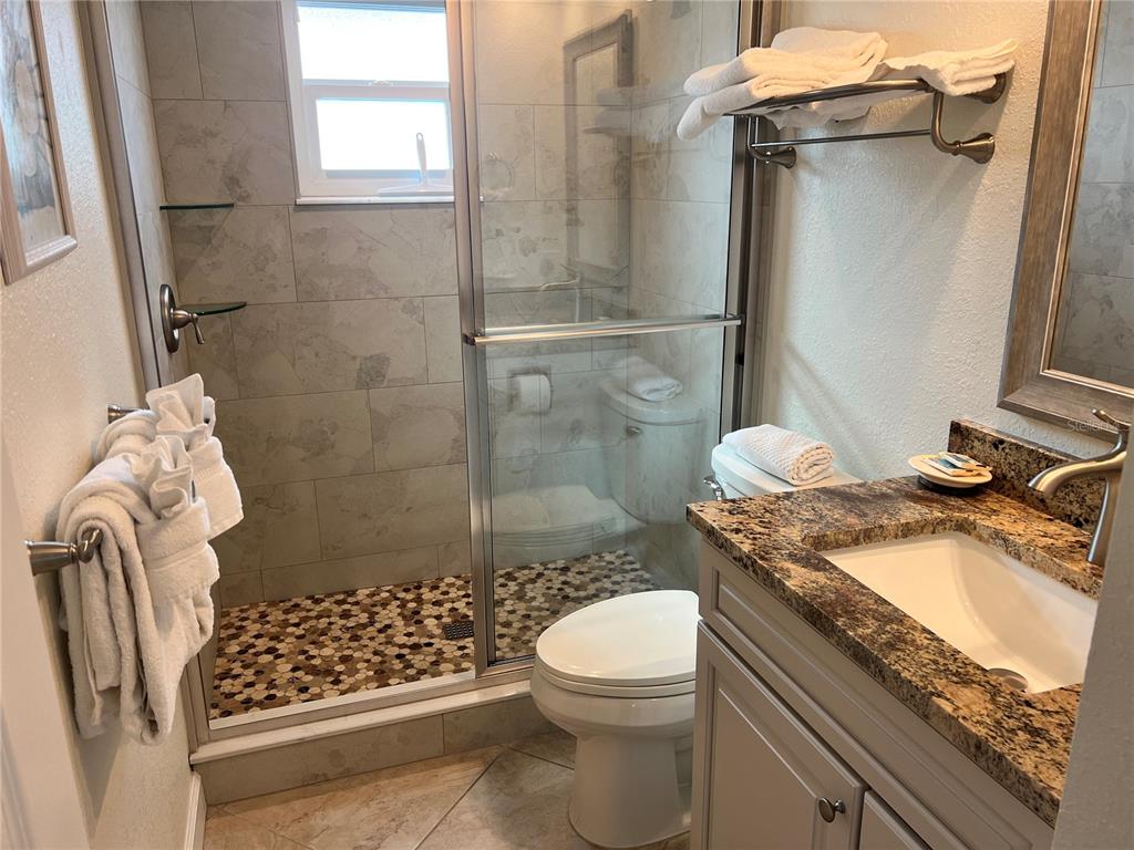 6154 Midnight Pass Road, Unit B07 Sarasota, FL 34242 - Photo 14 of 15 a bathroom with a granite countertop sink a toilet and shower